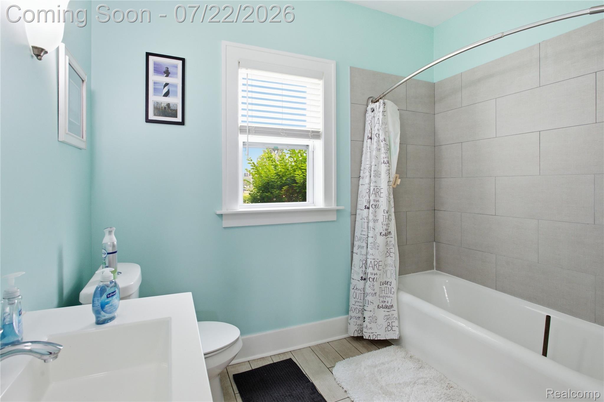 32127 Utica Road Fraser, MI 48026 - Photo 17 of 43 Bathroom featuring a white vanity with integrated sink, chrome faucet, white toilet, and a bathtub with gray subway tile surround