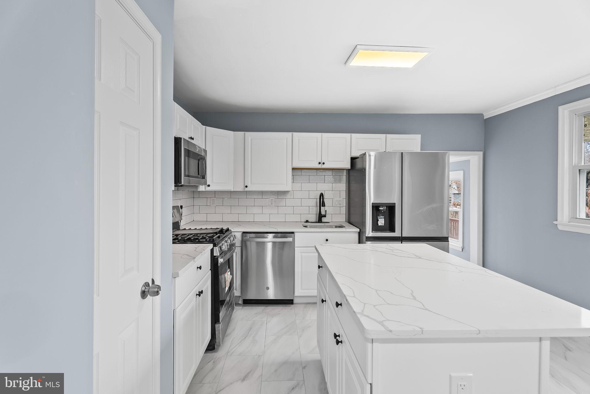 4302 Henderson Road Temple Hills, MD 20748 - Photo 12 of 33 a kitchen with a refrigerator a stove top oven a sink and cabinets