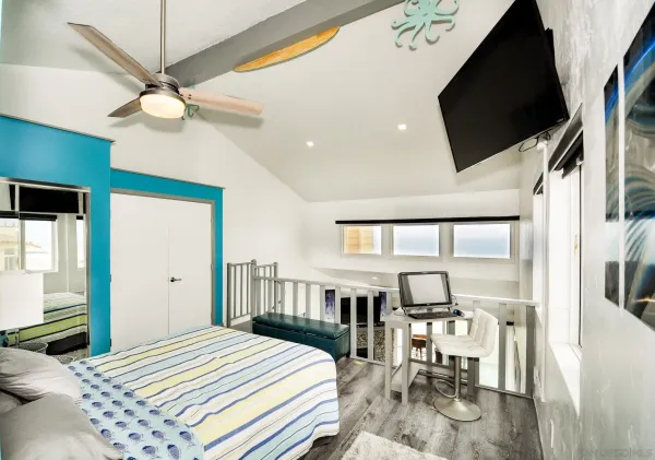 a bedroom with a bed a flat screen tv and a chandelier