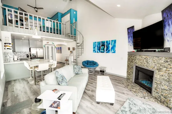 a living room with furniture a flat screen tv and a fireplace