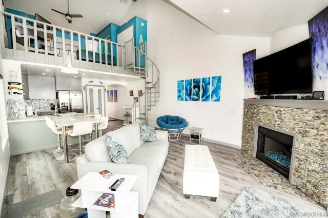 a living room with furniture a flat screen tv and a fireplace
