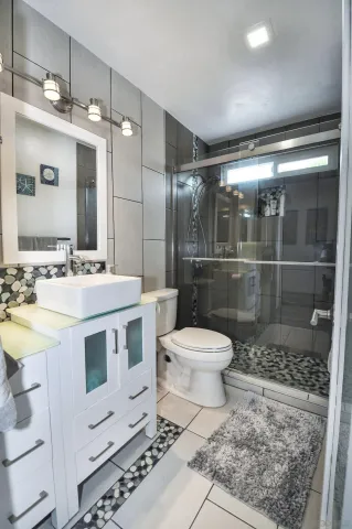 a bathroom with a sink a toilet and shower