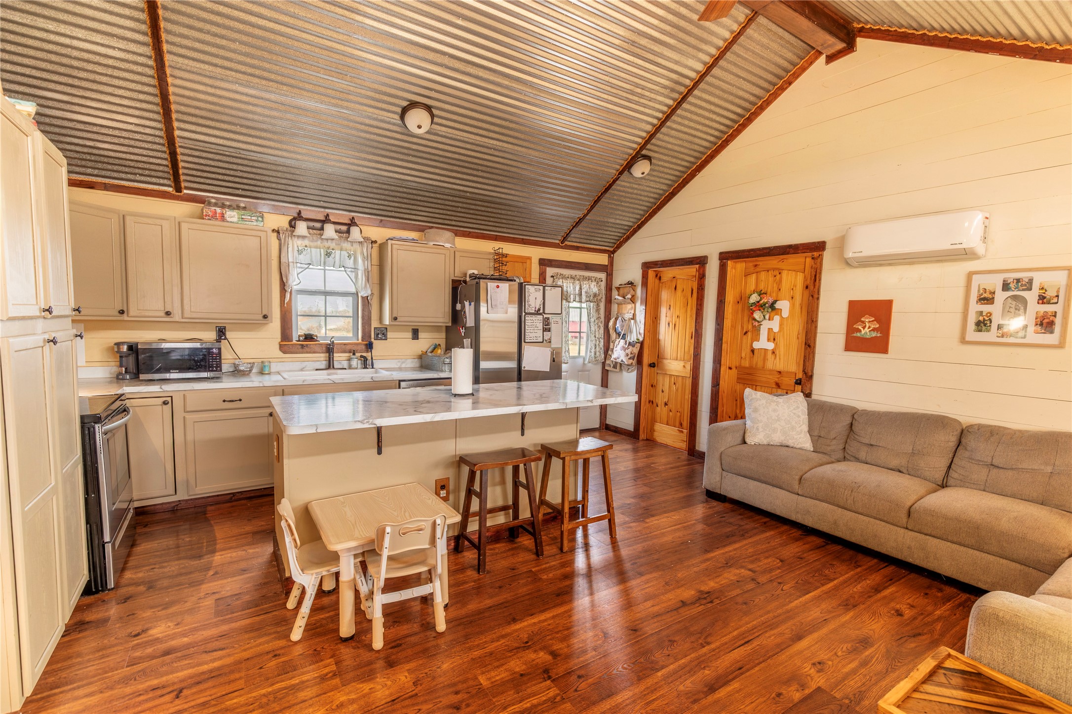 a large kitchen with a table chairs refrigerator and cabinets