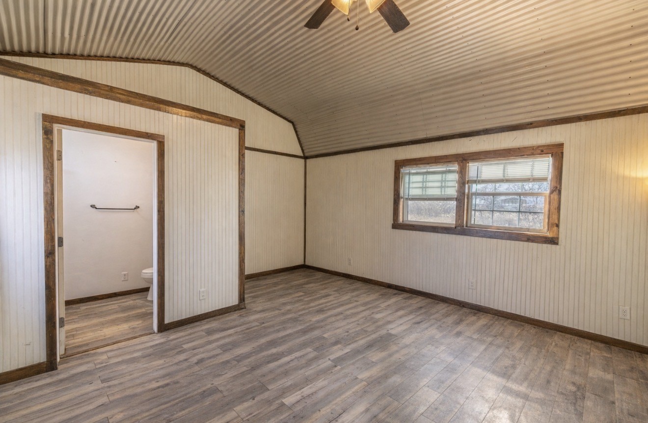 2726 Remmert Road Bellville, TX 77418 - Photo 16 of 18 an empty room with wooden floor chandelier fan and windows