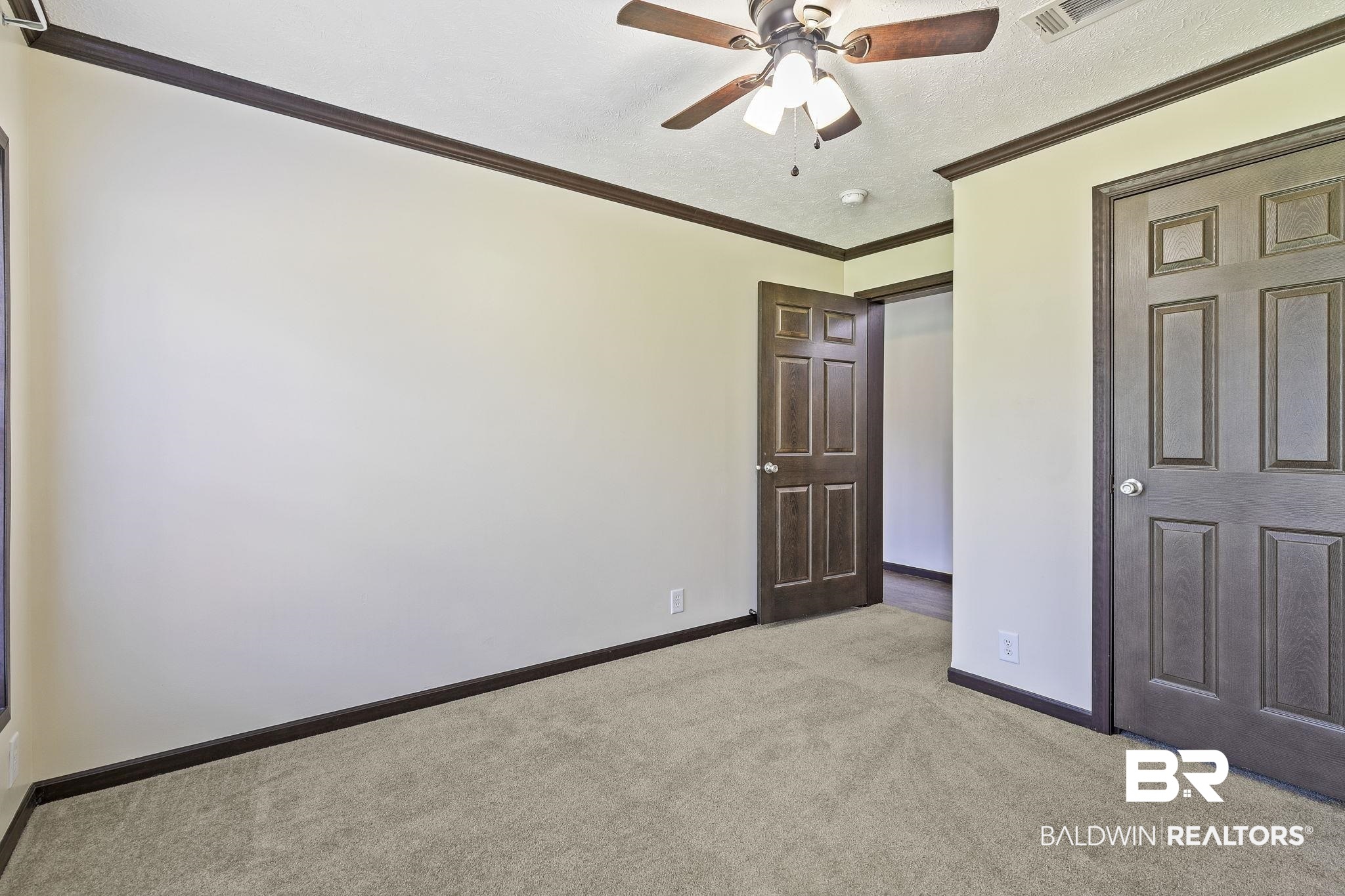 35641 County Road 39 Stapleton, AL 36578 - Photo 29 of 46 Unfurnished bedroom with light carpet, a textured ceiling, ceiling fan, and crown molding