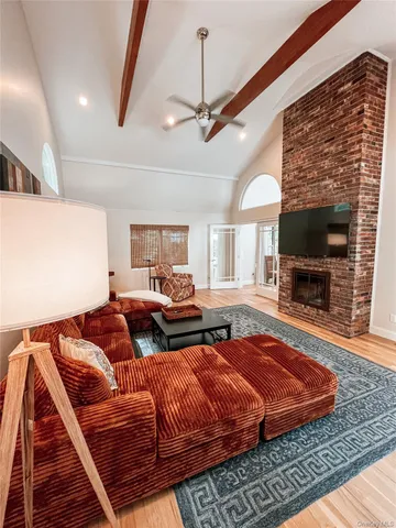 a living room with furniture a flat screen tv and a fireplace