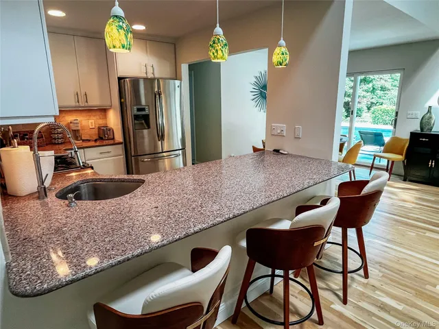 a kitchen with a table chairs and refrigerator