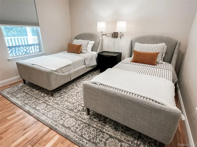a bedroom with two beds and wooden floor