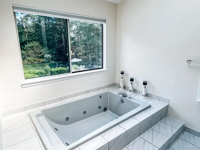 a bathroom with a tub sink and window