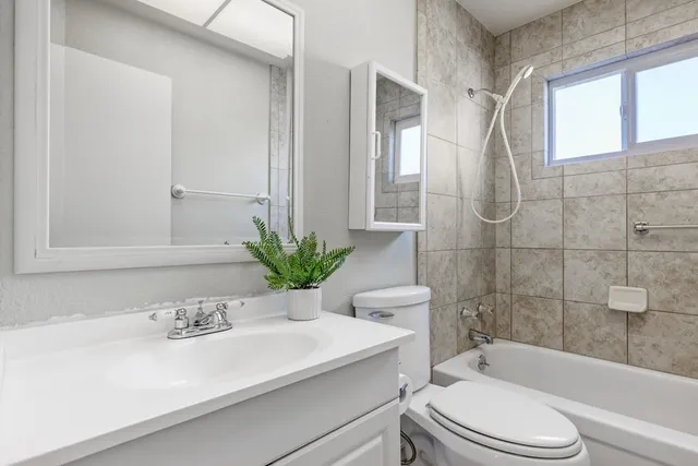 a bathroom with a sink a toilet a tub and shower