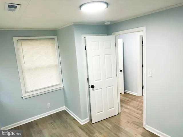 an empty room with wooden floor and white wall