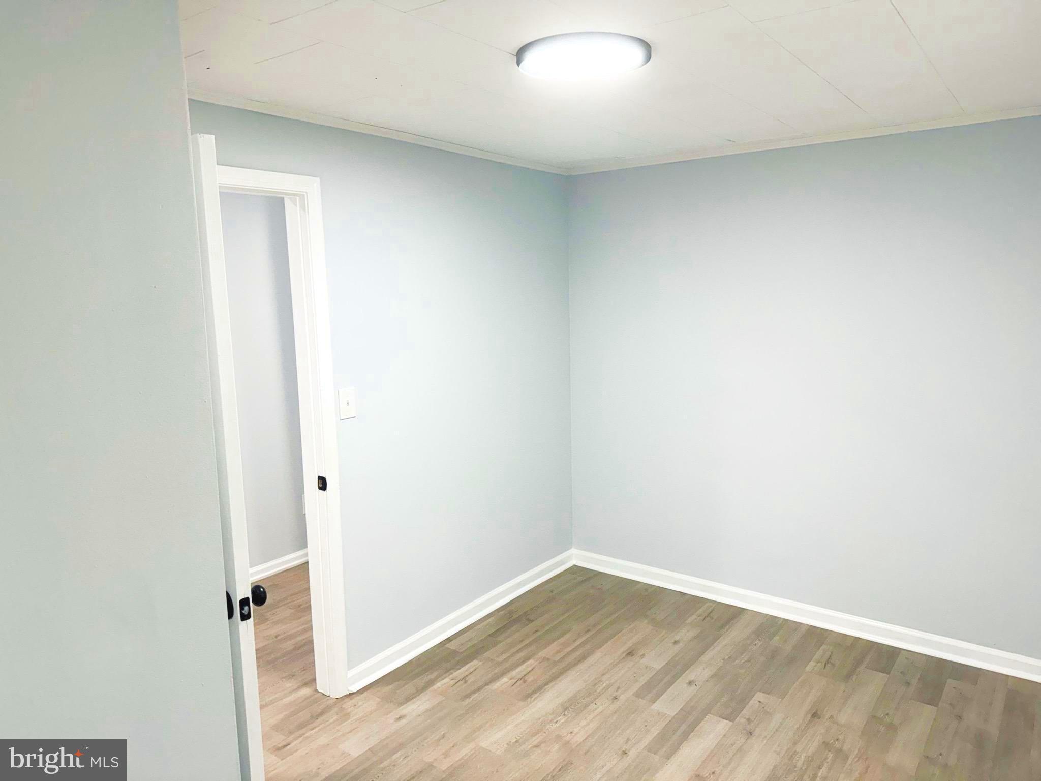 203 Henson Road Glen Burnie, MD 21060 - Photo 15 of 44 an empty room with wooden floor and white wall