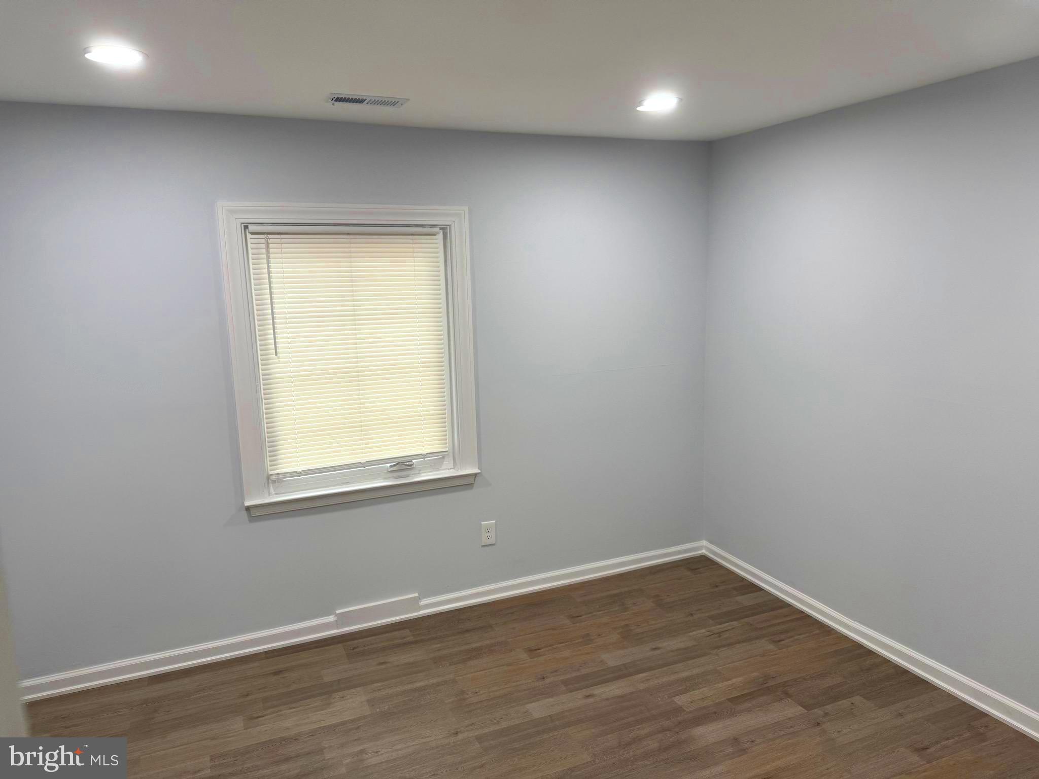 203 Henson Road Glen Burnie, MD 21060 - Photo 20 of 44 an empty room with wooden floor and windows