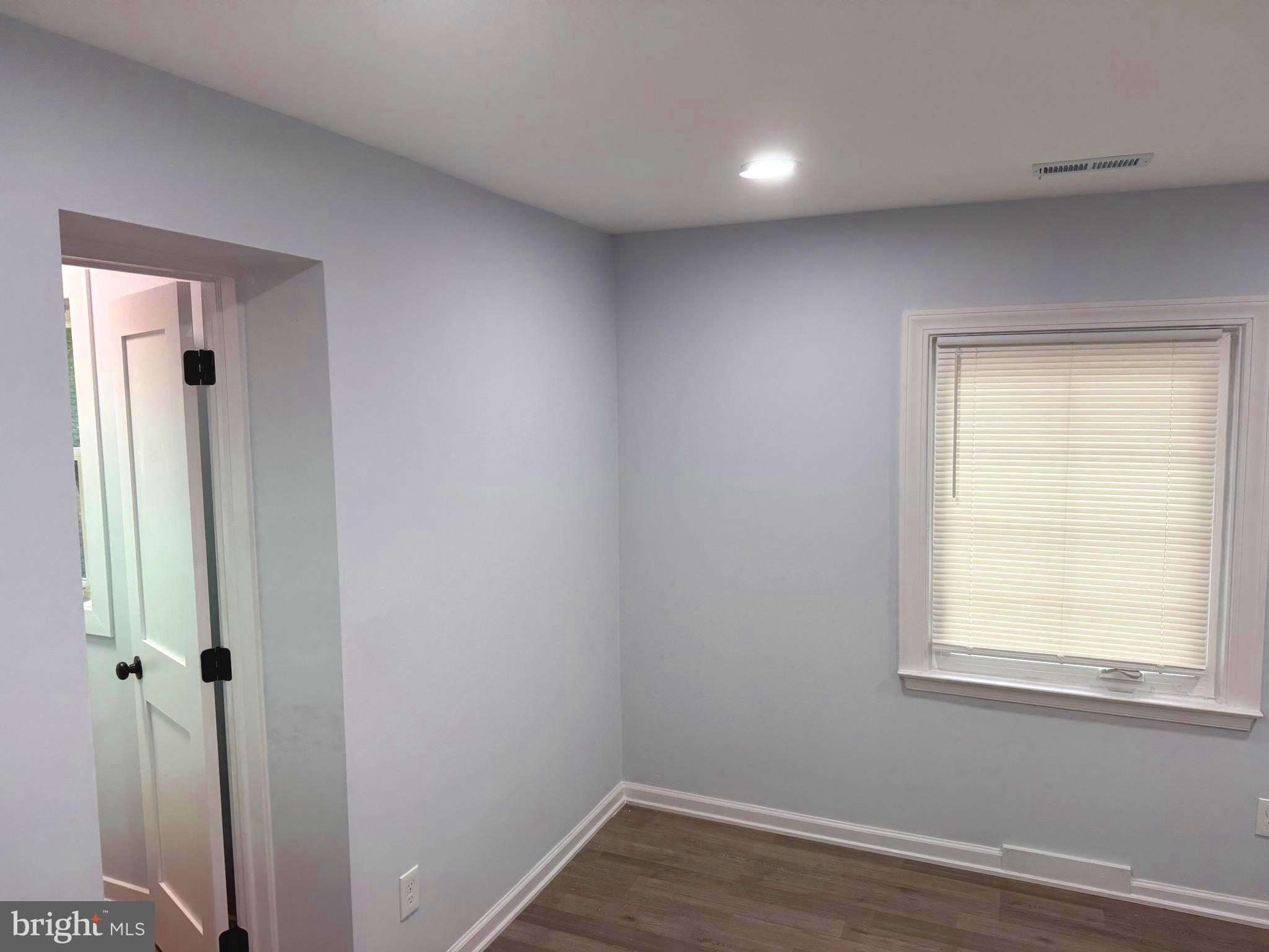 203 Henson Road Glen Burnie, MD 21060 - Photo 21 of 44 an empty room with wooden floor and a window