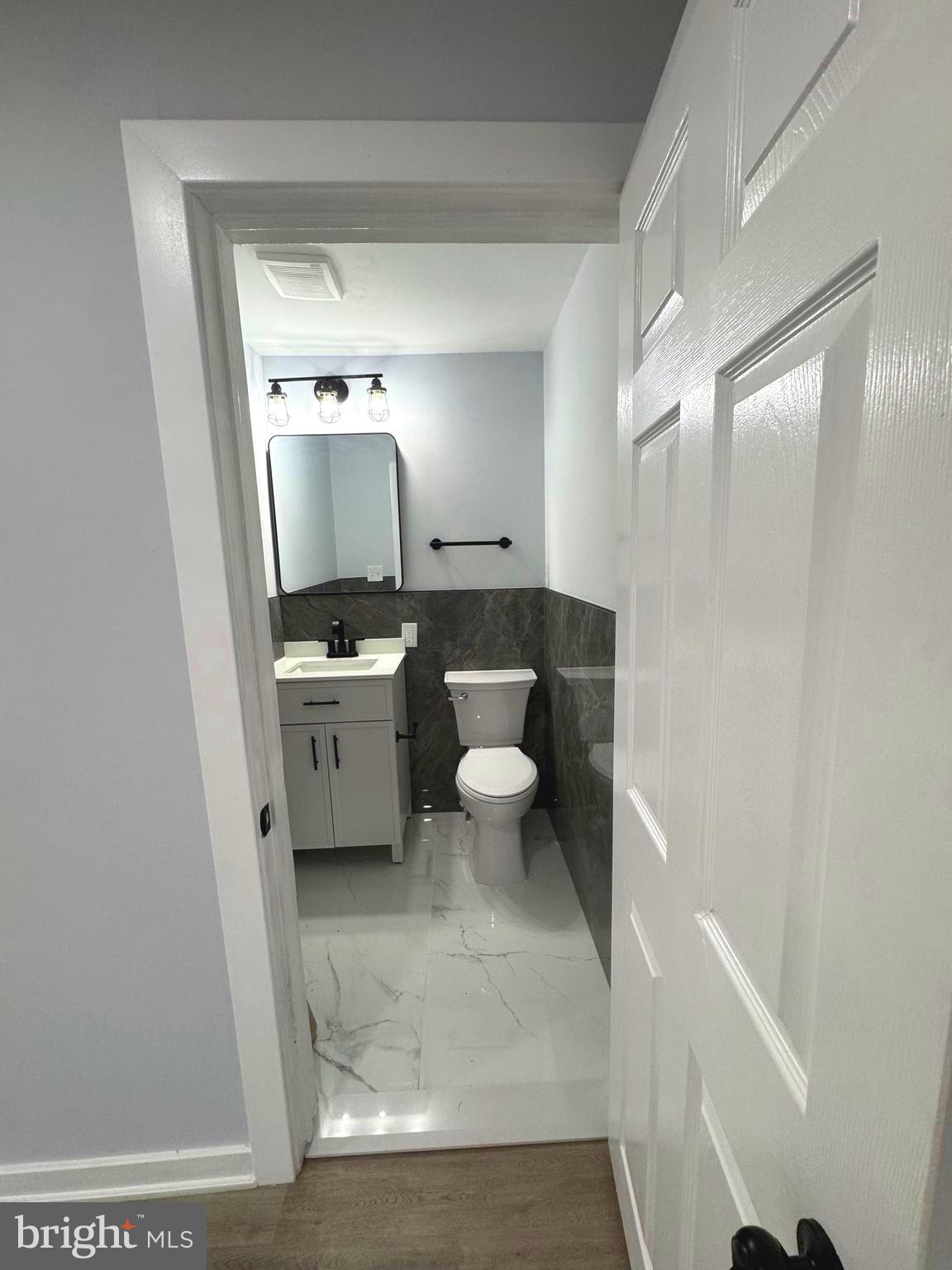 203 Henson Road Glen Burnie, MD 21060 - Photo 33 of 44 a bathroom with a sink a toilet a mirror and vanity