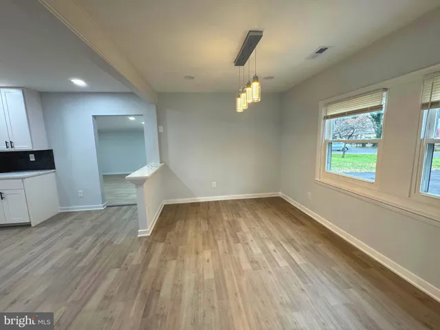 a large kitchen with stainless steel appliances kitchen island a large counter top and a view of living room