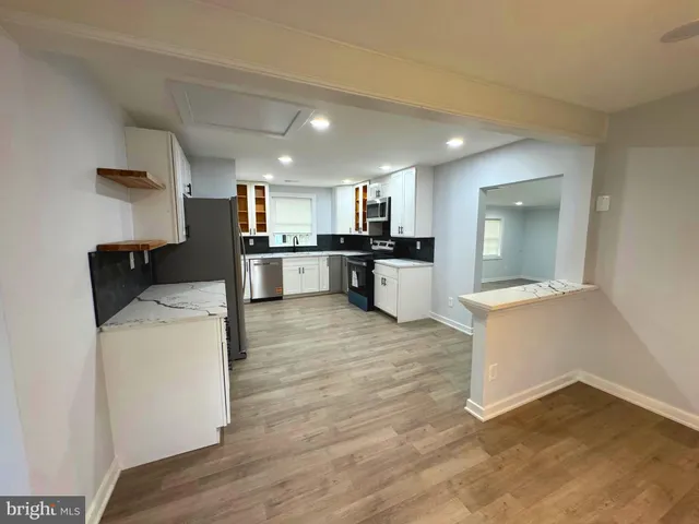 a large kitchen with a sink a refrigerator and a stove