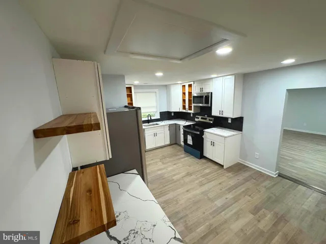 a kitchen with granite countertop white cabinets and stainless steel appliances
