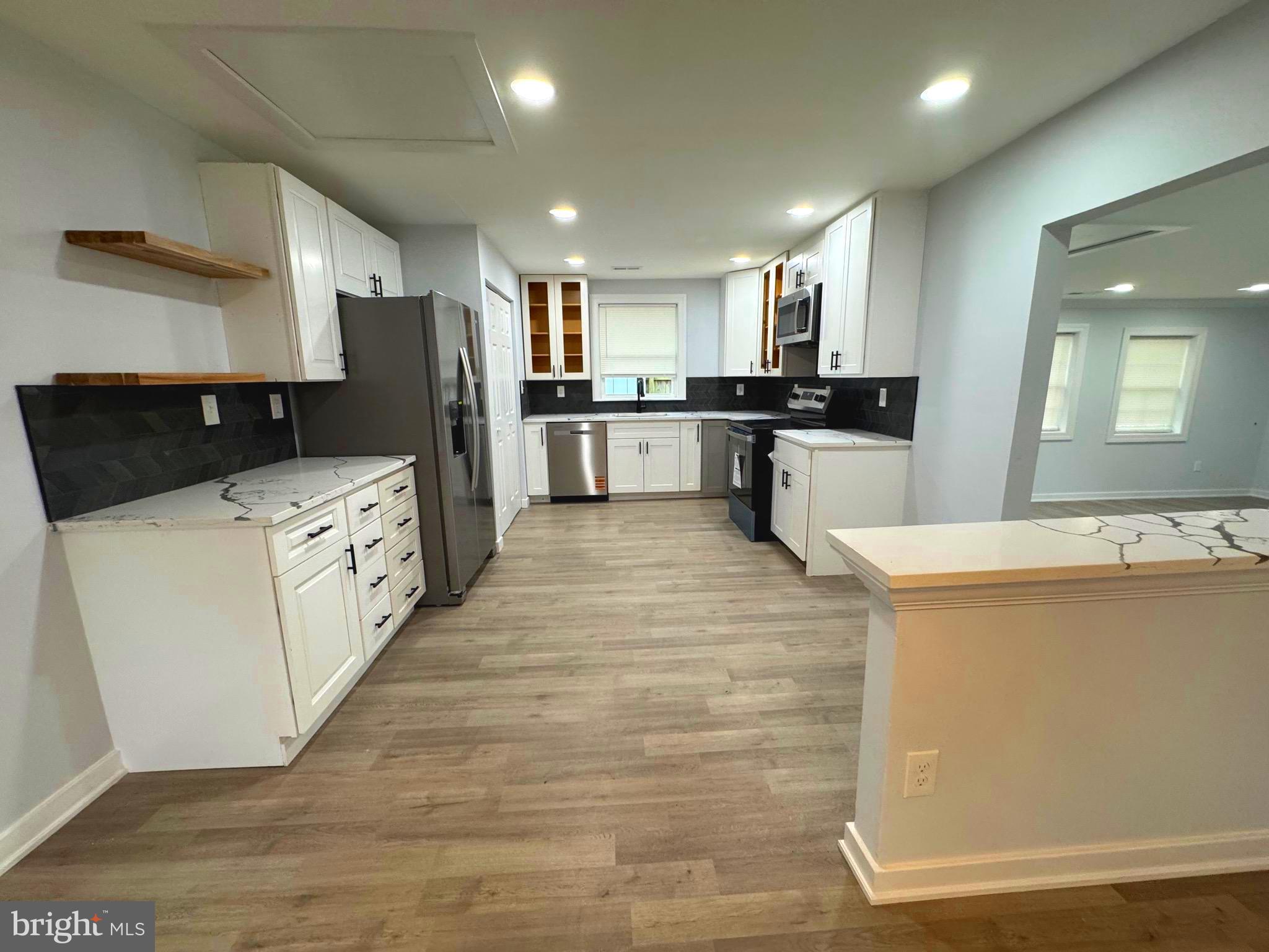 203 Henson Road Glen Burnie, MD 21060 - Photo 37 of 44 a large kitchen with stainless steel appliances kitchen island a large counter top and a view of living room
