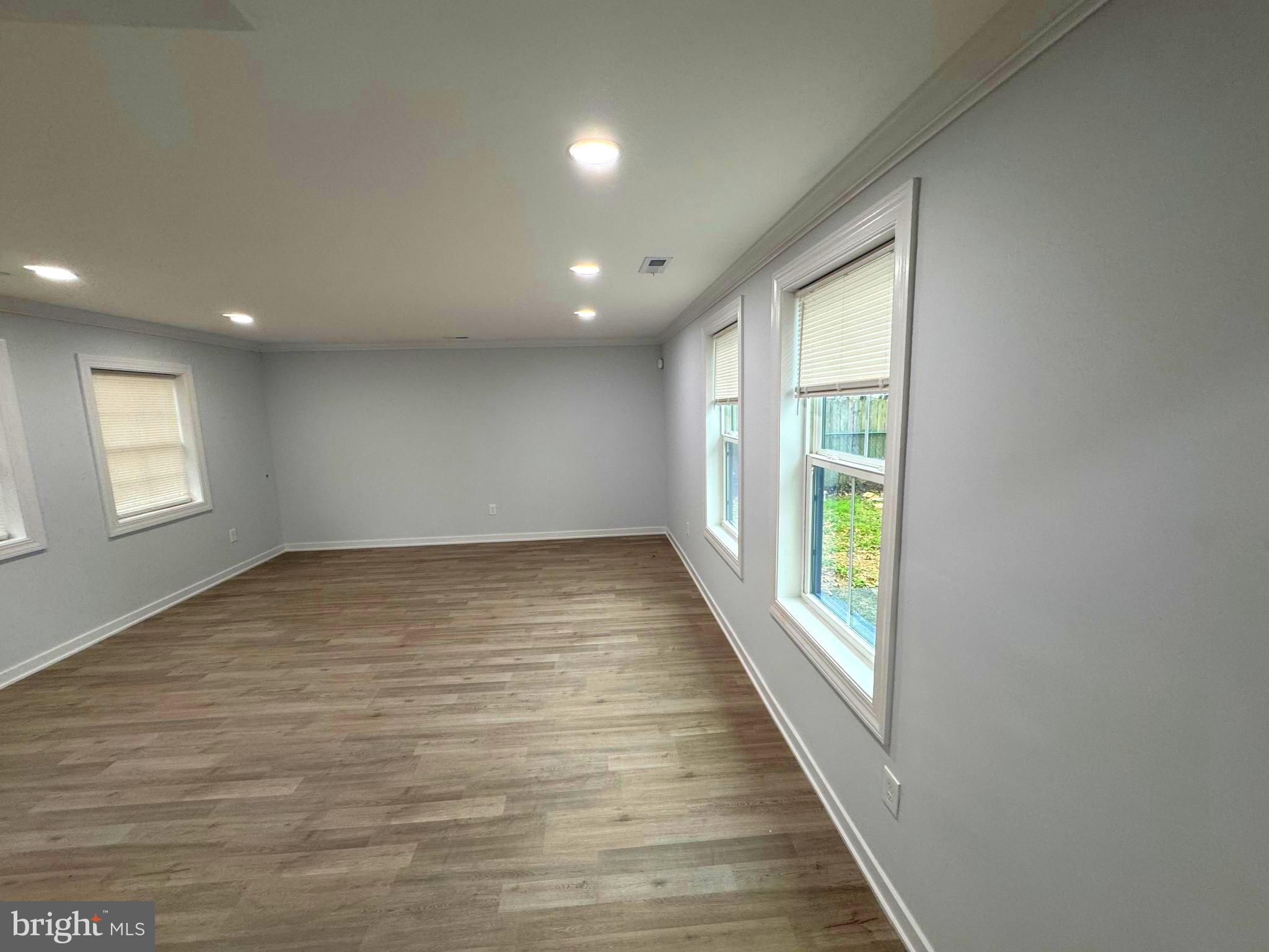 203 Henson Road Glen Burnie, MD 21060 - Photo 43 of 44 an empty room with wooden floor and windows