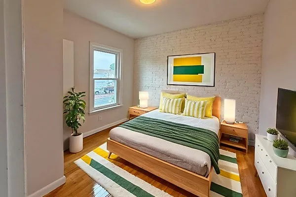 a bedroom with a bed and a potted plant