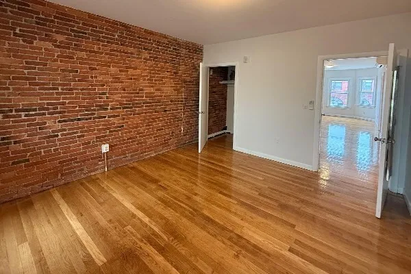 a view of an empty room with wooden floor
