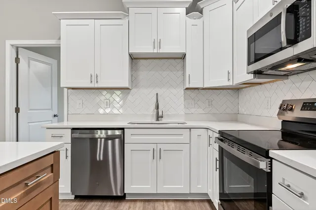 a kitchen with cabinets appliances and a sink