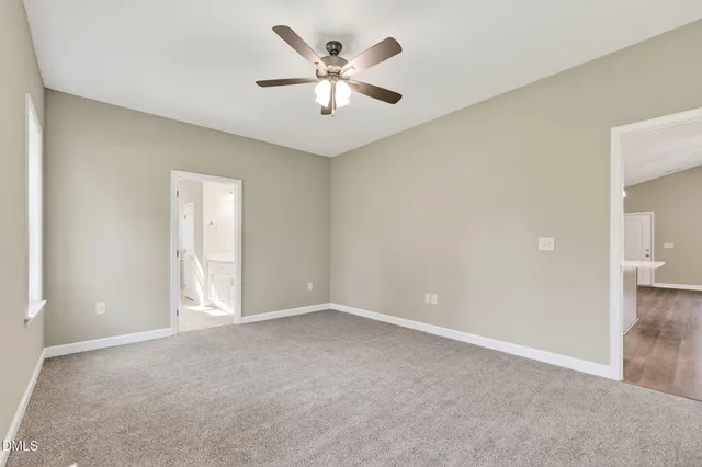 an empty room with closet and fan