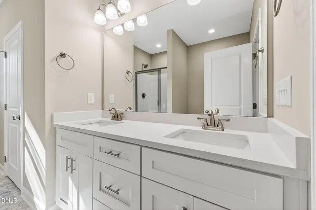 a bathroom with double vanity sinks and a mirror
