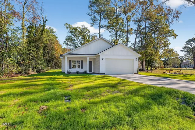 a front view of a house with yard and green space