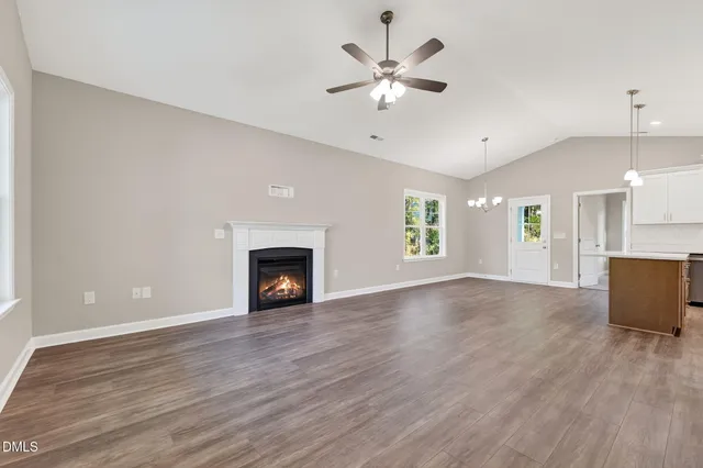 an empty room with large windows and a fireplace