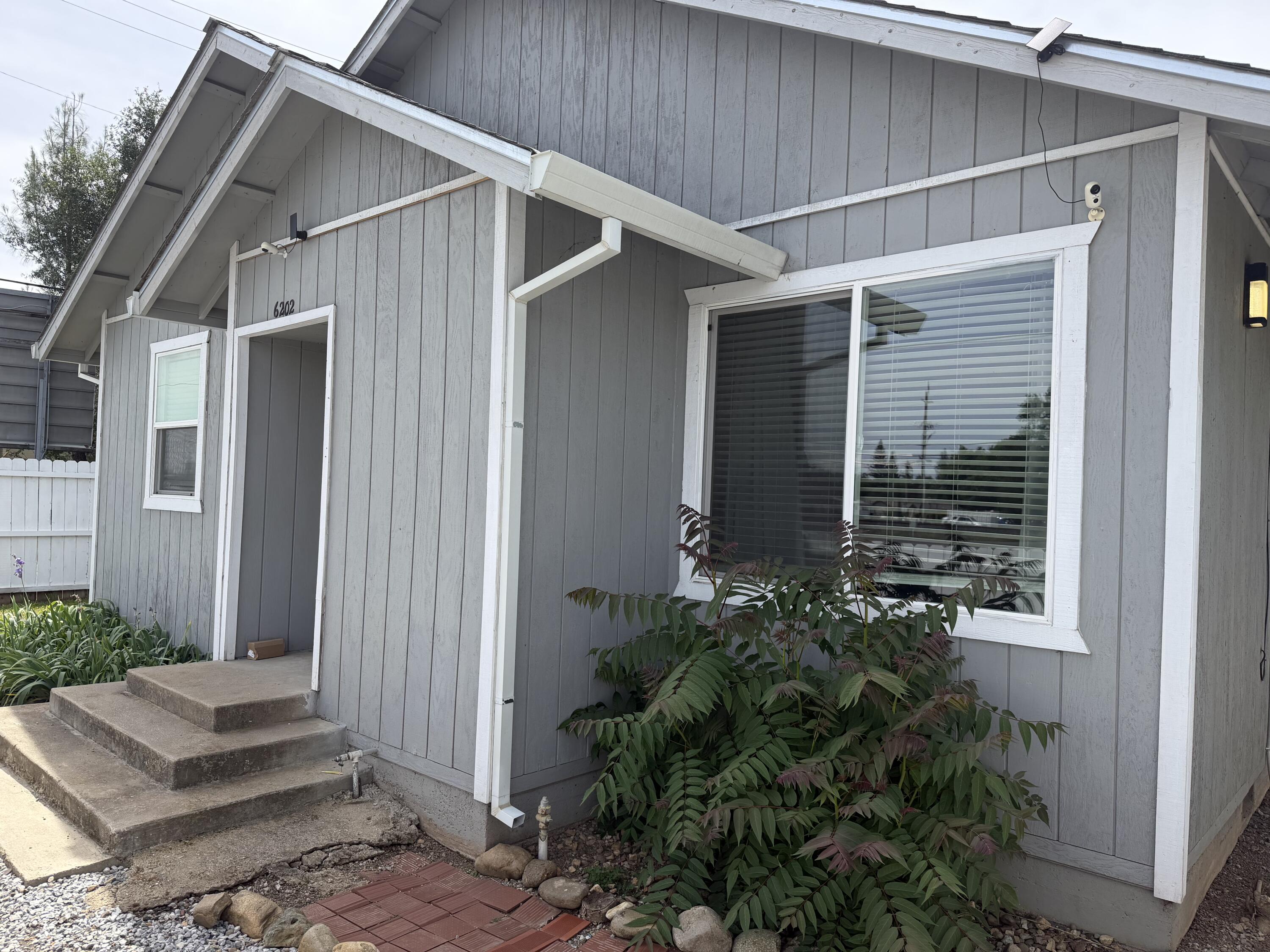 6200 Westside Road Redding, CA 96001 - Photo 2 of 50 a view of house with wooden walls and potted plants