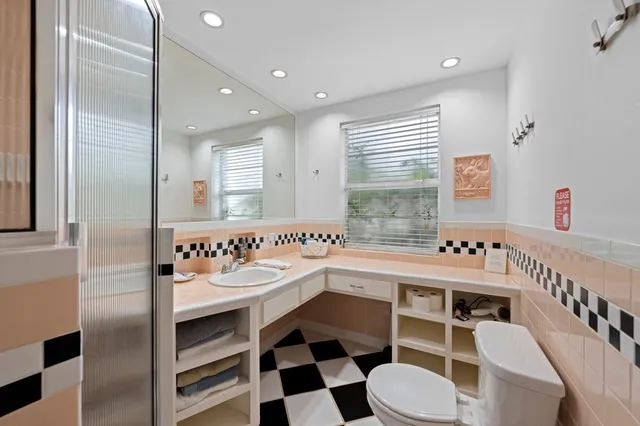 a large white bathroom with a sink a toilet a mirror and bathtub