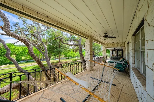 a view of a patio with table and chairs and floor to ceiling window with wooden floor