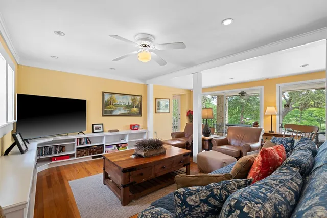 a living room with furniture a flat screen tv and a large window