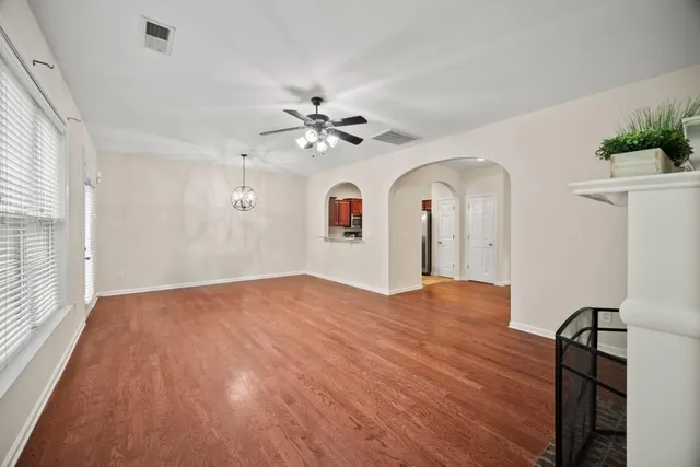 a view of empty room with window and wooden floor