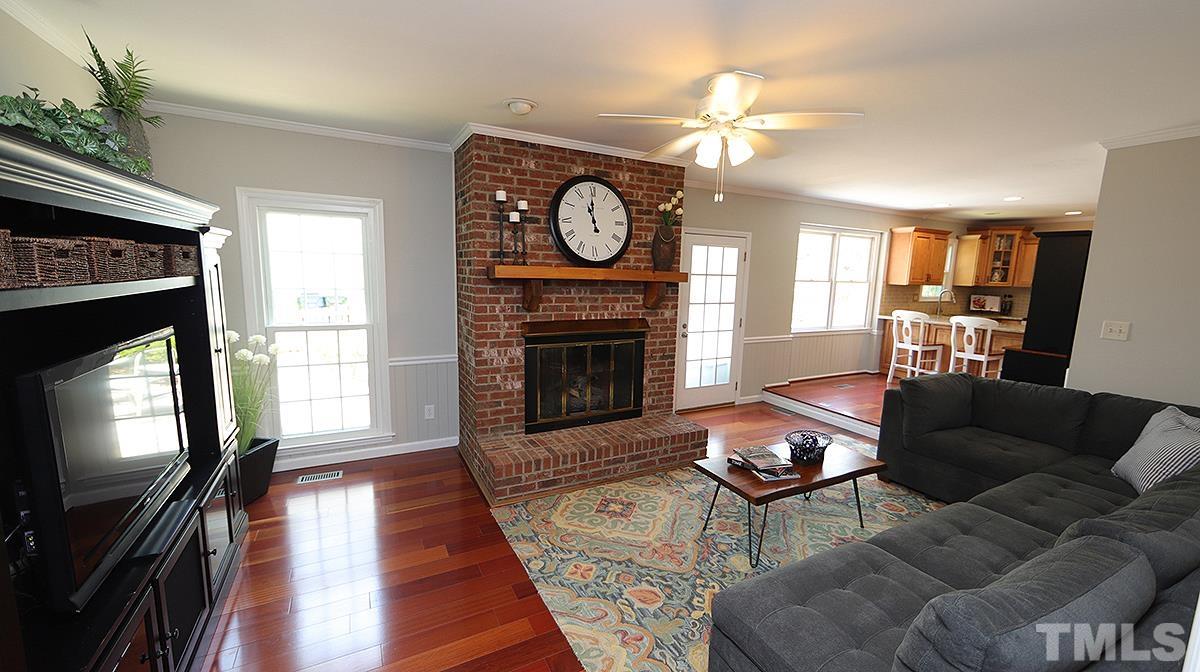 2504 Sawmill Road Raleigh, NC 27613 - Photo 3 of 13 a living room with furniture a fireplace and a flat screen tv