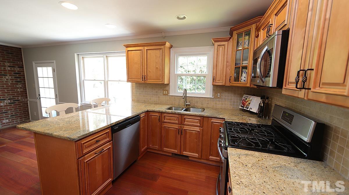 2504 Sawmill Road Raleigh, NC 27613 - Photo 5 of 13 a kitchen with stainless steel appliances granite countertop a sink stove and cabinets