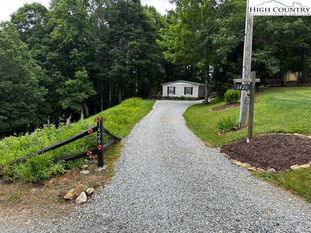1426 Rainbow Trail Boone, NC 28607 - Photo 31 of 48 a green field with lots of trees in the background