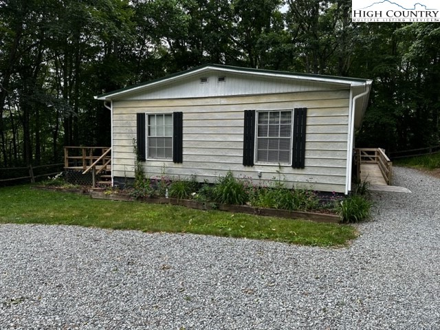 1426 Rainbow Trail Boone, NC 28607 - Photo 34 of 48 a white house with a small yard and large trees