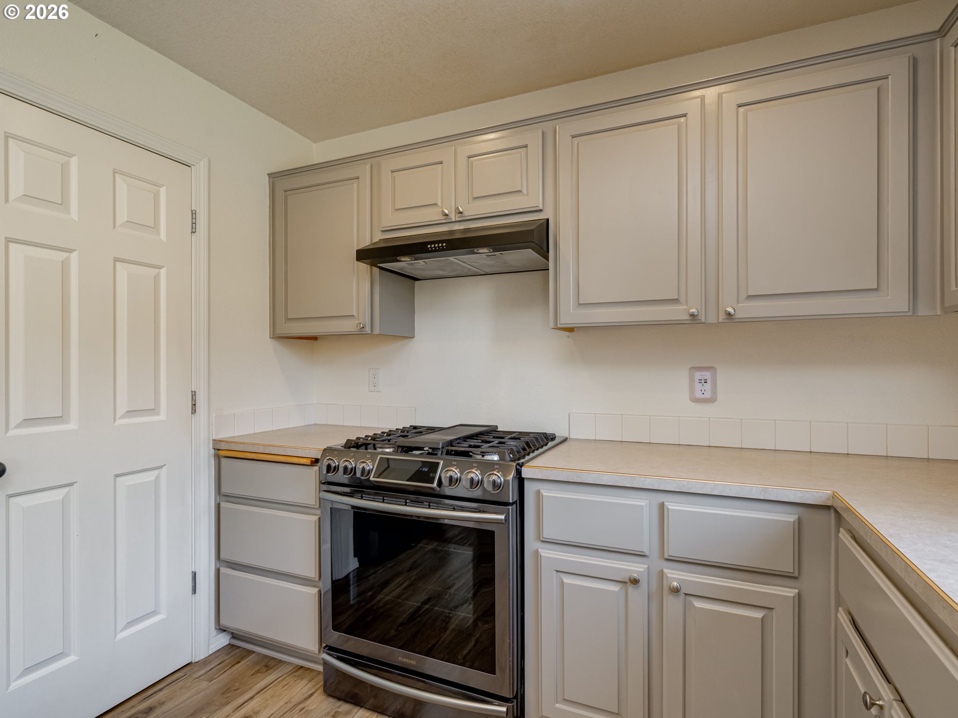 1312 Northwest 9th Way Battle Ground, WA 98604 - Photo 17 of 39 a kitchen with white cabinets and a stove top oven