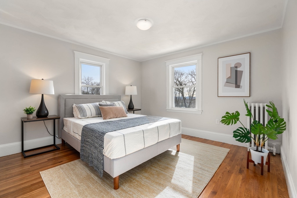 89 Coolidge Road Arlington, MA 02476 - Photo 13 of 22 a bedroom with a bed lamp and wooden floor