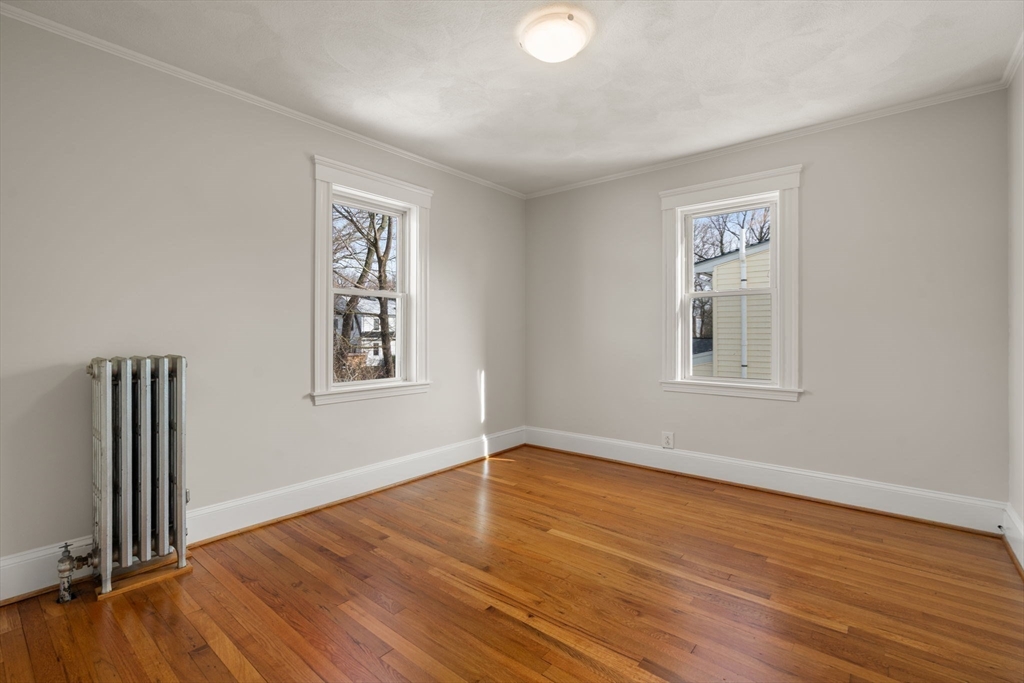 89 Coolidge Road Arlington, MA 02476 - Photo 15 of 22 a view of an empty room with wooden floor and a window