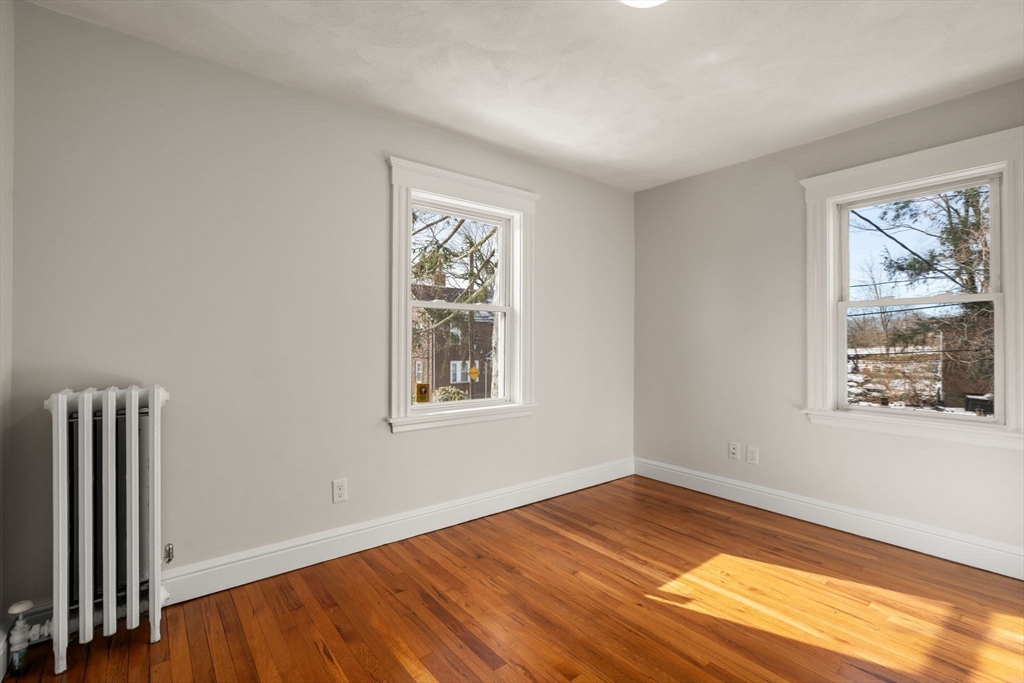 89 Coolidge Road Arlington, MA 02476 - Photo 16 of 22 a view of an empty room with wooden floor and a window