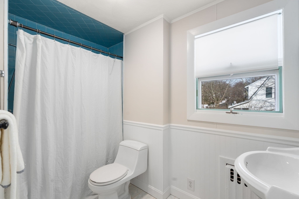 89 Coolidge Road Arlington, MA 02476 - Photo 18 of 22 a white toilet sitting next to a bathroom sink