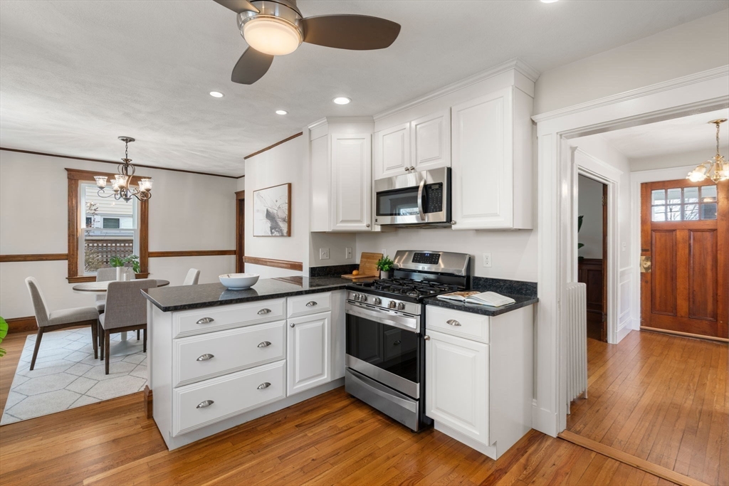 89 Coolidge Road Arlington, MA 02476 - Photo 9 of 22 a kitchen with granite countertop a sink cabinets and wooden floor