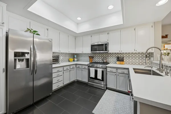 a kitchen with a refrigerator sink and white cabinets