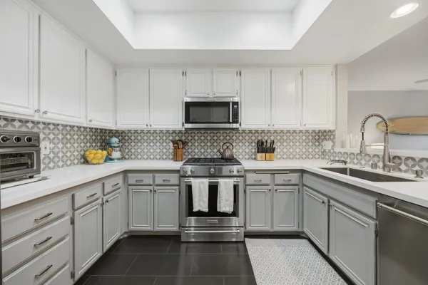 a kitchen with cabinets appliances a sink and a counter top space