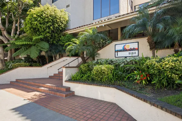 a view of a street with potted plants