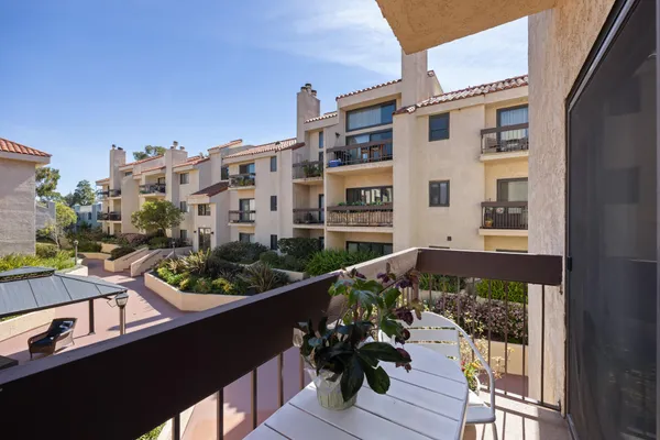 a view of a balcony with chairs and a potted plant